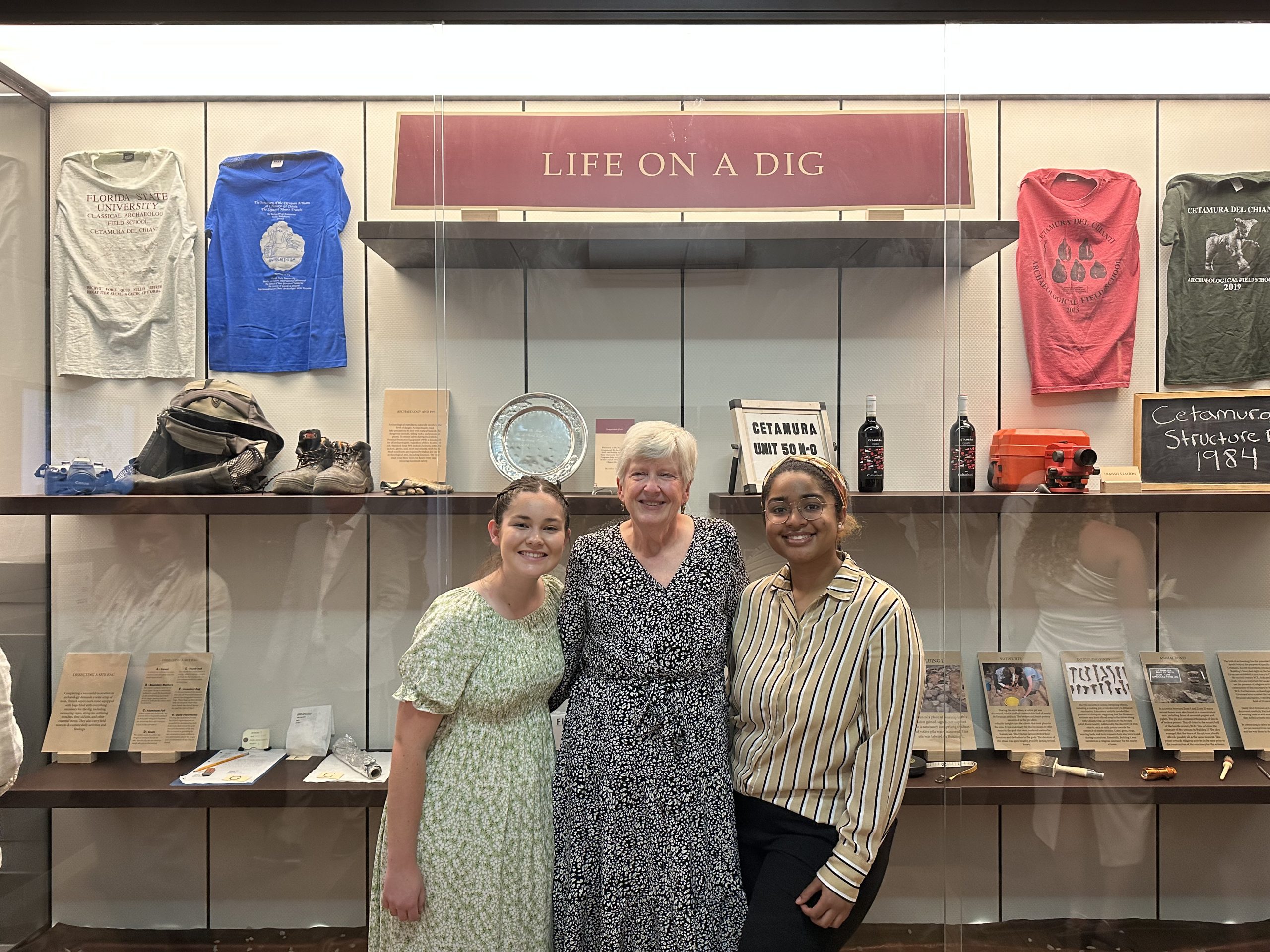 three women standing in front of display case